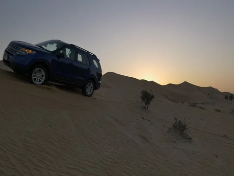 Car Driving Through Desert in Abu Dhabi at Dusk 1 Stock Footage 77753284