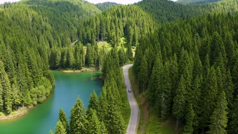 Car driving through the forest and the lake on the side. Beautiful mountain road Stock Footage 150586792