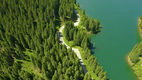 Car driving through the forest and the lake on the side. Beautiful mountain road Stock Footage 150589010