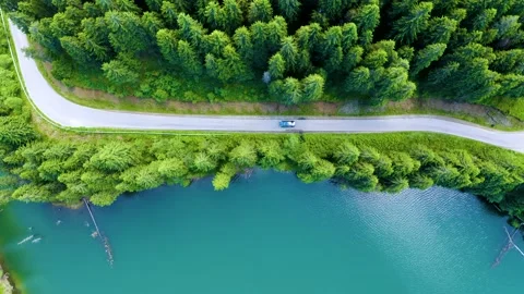 Car driving through the forest and the lake on the side. Beautiful mountain road Stock-Footage 150589538