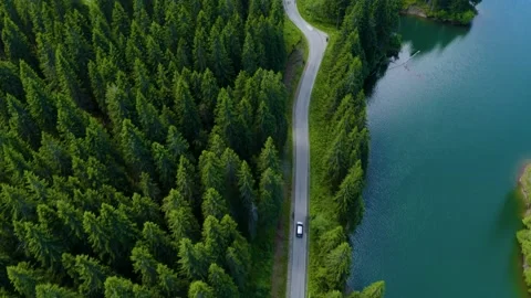 Car driving through the forest and the lake on the side. Beautiful mountain road 스톡 동영상 150589596