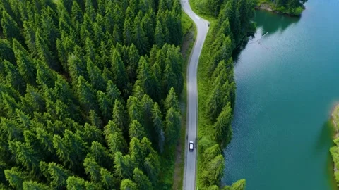 Car driving through the forest and the lake on the side. Beautiful mountain road Stock Footage 150589623
