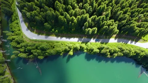 Car driving through the forest and the lake on the side. Beautiful mountain road 스톡 동영상 150589722