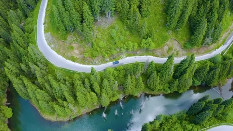 Car driving through the forest and the lake on the side. Beautiful mountain road Stock Footage 150589784