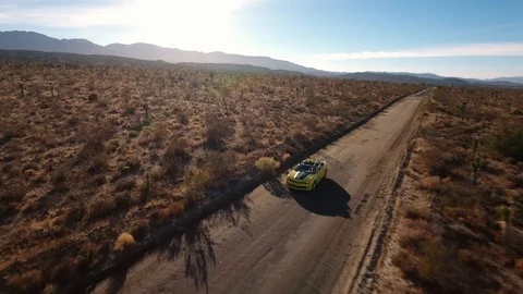 Car driving through the Joshua tree desert, aerial shot Stock Footage 90097306