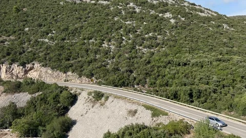 Car driving through the mountain road near steep area, green mountains Stock-Footage 288843635