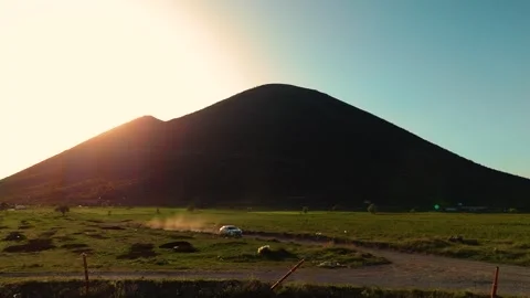 Car Driving Through Mountainous Terrain at Sunset Stock Footage 274097218