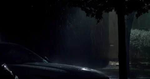 A car driving through a parking lot while it rains, heavy rain storm at Stock Footage 263196994