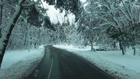 Car driving through snowy pine forest in winter aerial drone footage Stock Footage 83727544