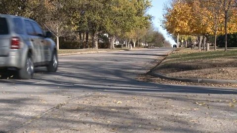 Car driving through suburban neighborhood Stock Footage