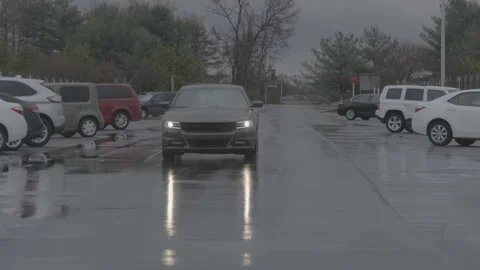 Car Driving Through Wet Parking Lot on Rainy Overcast Day Stock Footage 343939363