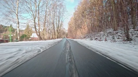 Car Driving Through Winter Forest Down Narrow Road Covered with Slush Snow Mud Stockbeeldmateriaal 326059195