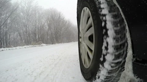 Car driving through a winter storm with snow on a forested road Stock Footage 59101284