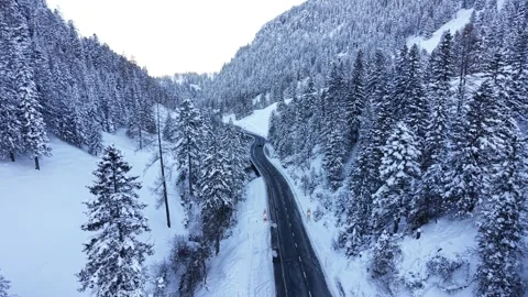 Car Driving Toward Camera on Winding Snowy Mountain Road With Headlights Stock-Footage 331643497