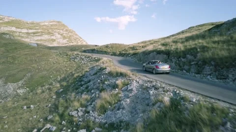 Car Driving on Winding Mountain Road in Sunny Montenegro Aerial Drone Footage Stock Footage 201152484