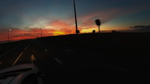 The car is eating on the road against the background of a crimson sunset Stock Footage 202102673