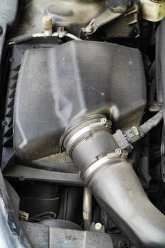 Car engine air filter box is very dirty.Black plastic box with pipes for ai.. Stock Photos