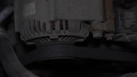 Car engine alternator with serpentine drive belt installed in vehicle. Stock Footage 344365722