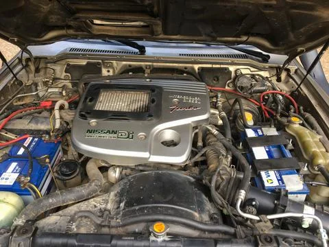 Car engine bay with open hood and dual batteries Stock Photos