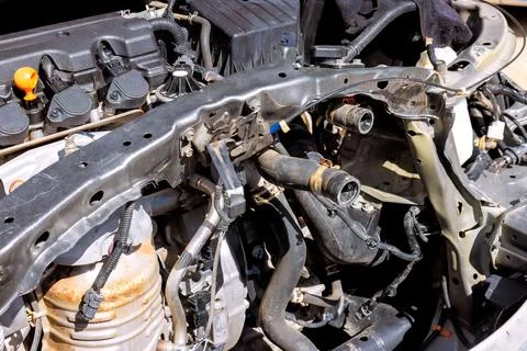 Car engine bay showing disassembled parts components during repair work in Stock Photos