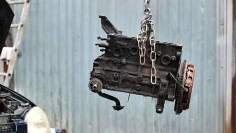 Car engine block hanging from a chain for repair Video stock 323401212