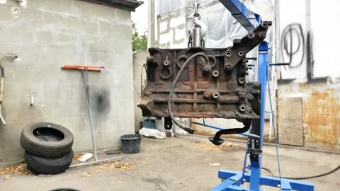 Car engine block on hoist in auto workshop Video stock 318138209