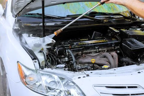 Car engine cleaning process in an outdoor location with pressure washer Stockfoto's