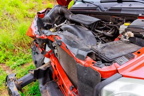 Car engine compartment displayed with exposed components damage in rural setting 写真素材