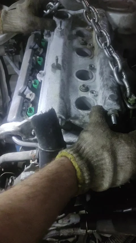 Car engine cylinder head being lifted by heavy metal chain Stock Footage 332921867