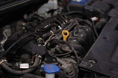 Car engine exposed beneath raised hood for professional servicing. Stock Photos