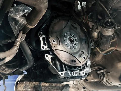 Car engine flywheel starter exposed during transmission repair maintenance Stock Photos