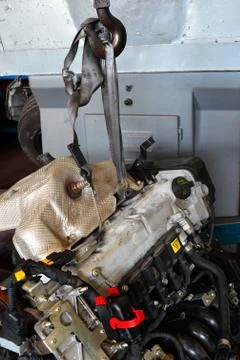 Car engine hanging from a elevator hook Stock Photos