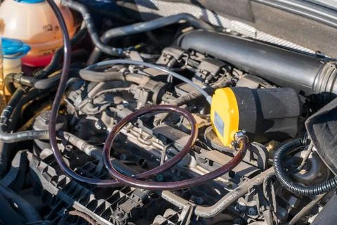 Car engine maintenance with fluid pump and hose close up Photos