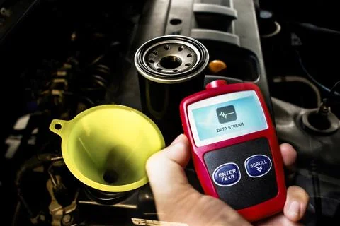 Car engine maintenance with oil filter, funnel, and OBD2 diagnostic scanner Stock Photos