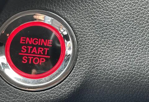 Car engine start stop button on dark leather background. copy space Foto stock