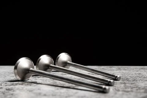 Car engine valves lie on the table on black background Stock Photos