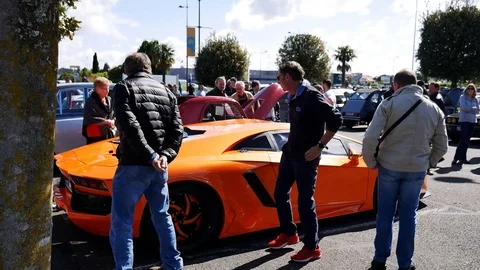Car enthusiasts looking at nice car 스톡 동영상 107632725