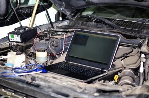 Car expert using laptop for auto diagnostics. Stock Photos