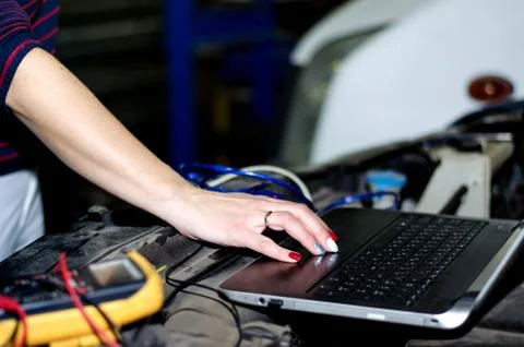 Car expert using laptop for auto diagnostics. Stock Photos