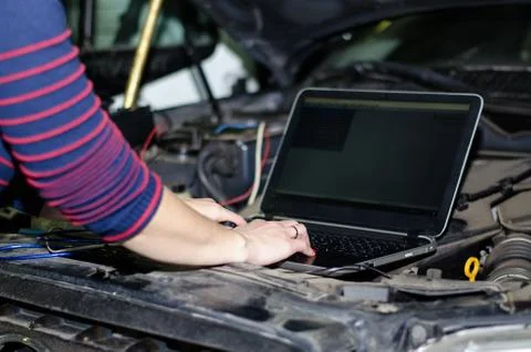 Car expert using laptop for auto diagnostics. Stock Photos