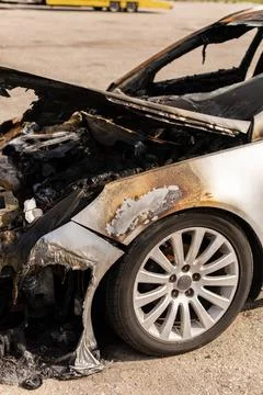 A car with extensive fire damage is parked in a lot. The charred interior r.. Stock Photos