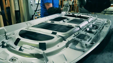 Car factory workers using structural adhesive at a car production factory Stock Footage 142305606