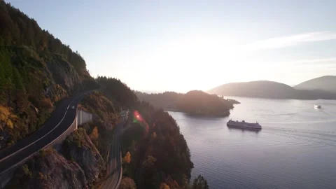Car ferry boat sailing into dock in scenic bay surrounded by mountains, sun rays Stock-Footage 221716680