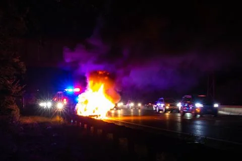 Car on fire night accident on the highway road Stock Photos