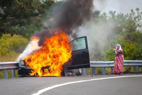 Car on fire with passengers Stock Photos