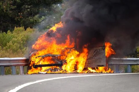 Car on fire with passengers Stock Photos