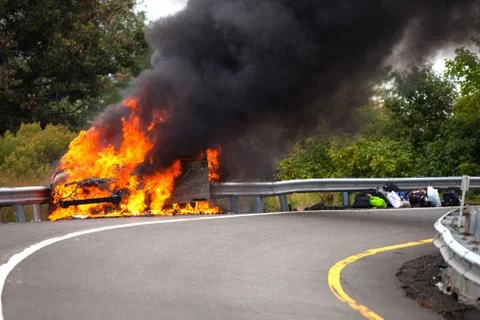 Car on fire with passengers 写真素材