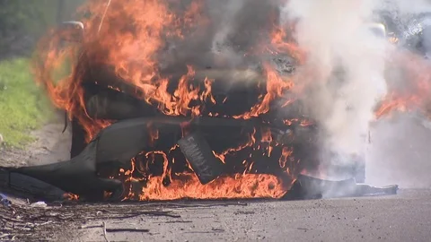 Car on fire on the side of a freeway Видео 72164754