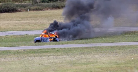 Car on fire by the side of the road Stock Footage 116239249