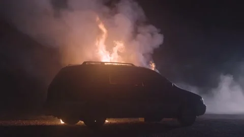 Car on fire slow motion. Burning automobile. Side view car in flames dark Stock Footage 220144140